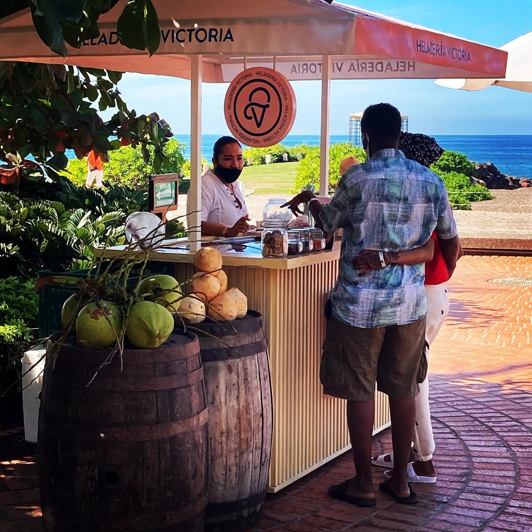 Puesto de Helados Victoria frente al mar, con clientes ordenando